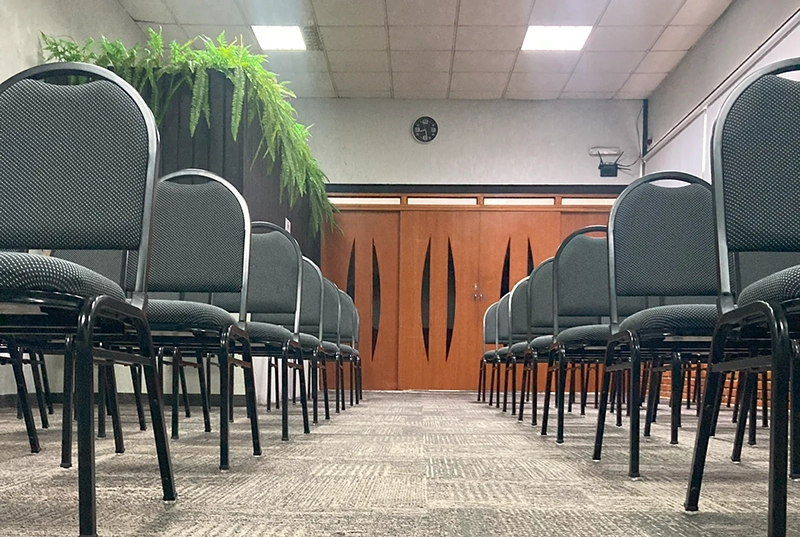 Cadeiras dispostas em auditorio Hellinger