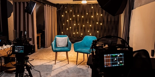 Estúdio audiovisual profissional com câmeras, iluminação e cenário